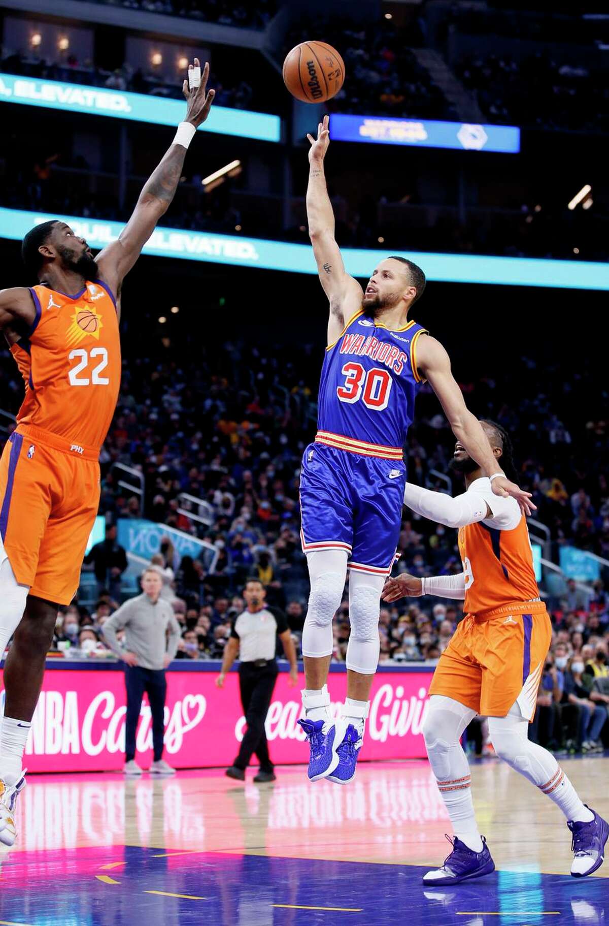 Golden State Warriors guard Stephen Curry (30) shoots the ball over Phoenix Suns center Deandre Ayton (22) for the two-point score in the third quarter of an NBA game at Chase Center, Friday, Dec. 3, 2021, in San Francisco, Calif.