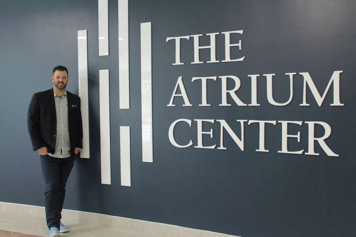 Ryan Bonifas, EMCID director of venue and events, displays the new sign welcoming guests to The Atrium Center.