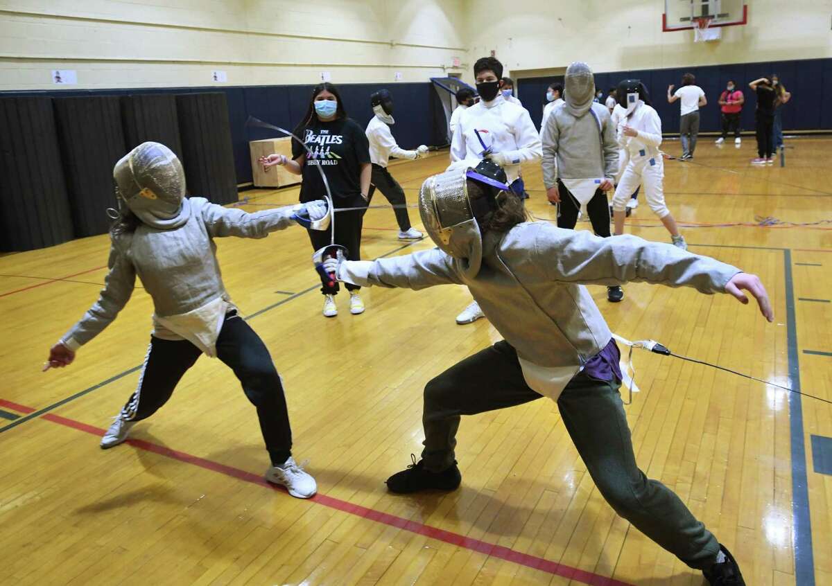 Junior Lea Schwartz, left, and sophomore Aaron DeHaener, both of Norwalk, fence with sabres during practice for the Center for Global Studies fencing team at Brien McMahon High School in Norwalk, Conn. on Thursday, November 18, 2021.