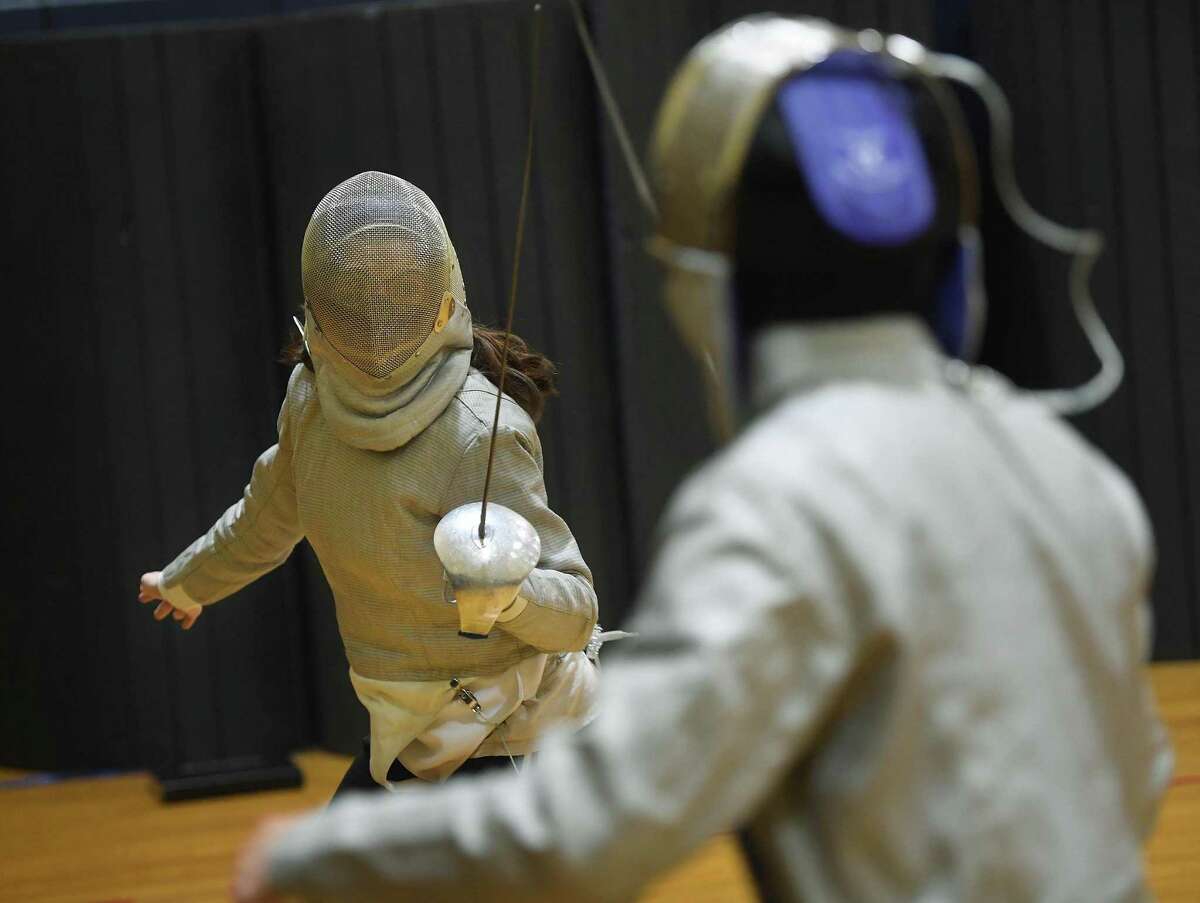 Juniors Lea Schwartz, left, and Haruki Nagata, both of Norwalk, fence with sabres during practice for the Center for Global Studies fencing team at Brien McMahon High School in Norwalk, Conn. on Thursday, November 18, 2021.
