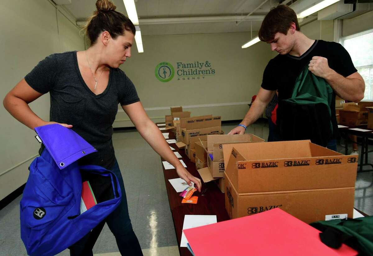 Volunteers from Albourne America, a local alternative investment firm, including Jackie Bernson and Evan Killeen fill 80 backpacks with school supplies for children in Family & Children’s Agency programs Thursday, August 22, 2019, at the FCA facility at Ben Franklin School in Norwalk, Conn.