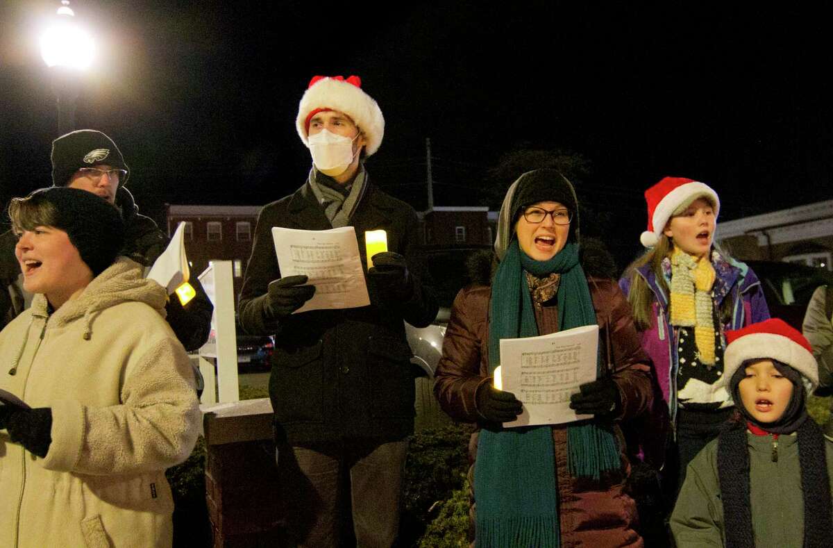 Members of the Christ Presbyterian Church sing Christmas carols during Downtown Milford Business Association's Lamplight Stroll in Milford, Conn., on Friday December 3, 2021. Along with dozens of businesses open and vendors lining the green along Broad Street, various fun holiday stops along the way like a visit with Santa, horse-drawn carriage rides and carolers that move around from store to store.