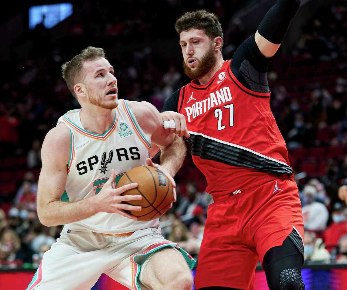 Spurs center Jakob Poeltl, left, drives to the basket as Trail Blazers center Jusuf Nurkic defends during the first half in Portland, Ore., Thursday, Dec. 2, 2021.