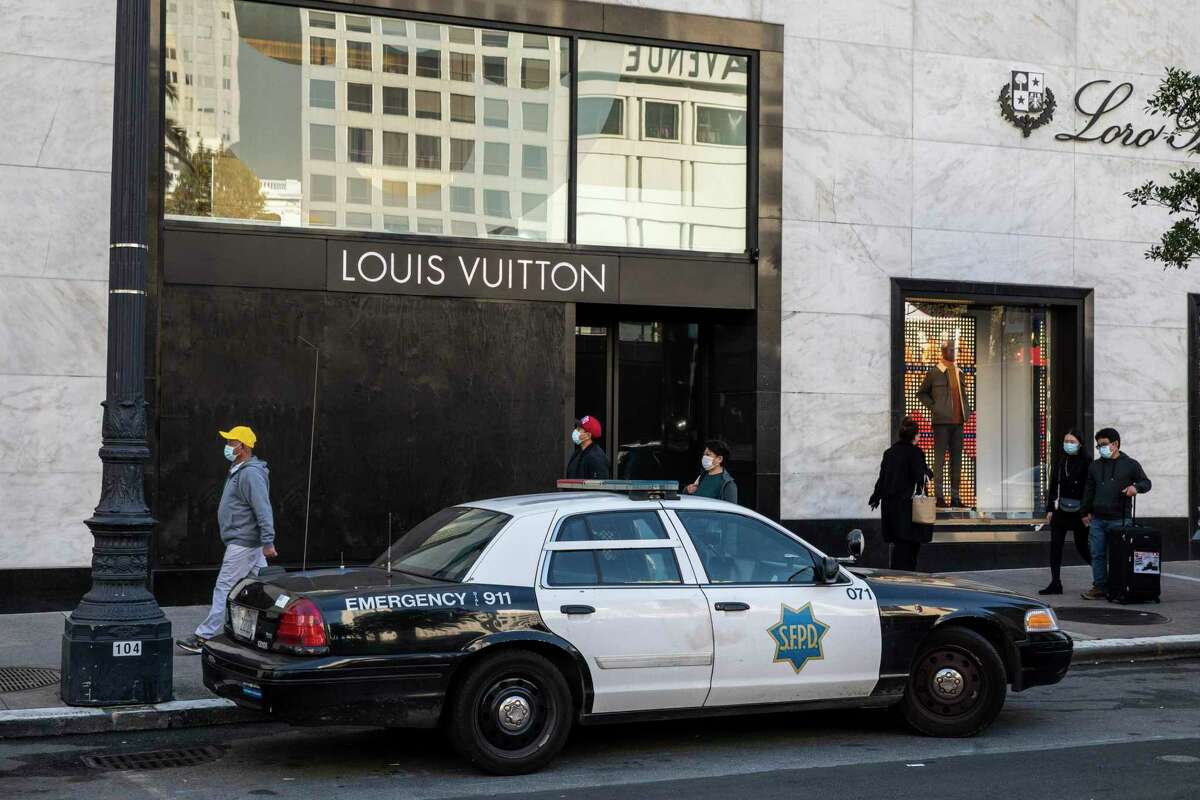 A police car is seen outside a barricaded Louis Vuitton store in Union Square. For some Black and brown shoppers who feel uncomfortable around police, holiday shopping this year could be a stressful time as law enforcement looks to deter potential retail theft.