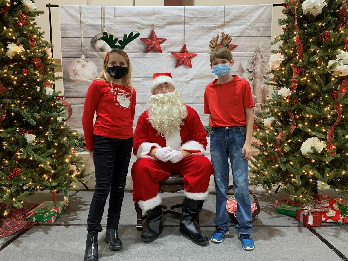 St. Mary's sixth-graders Elle May (left) and Lucas Frohnert (right) get their picture taken with Santa Claus at St. Mary's Breakfast with Santa on Saturday. The sixth graders were in charge of organizing and setting up the event. 