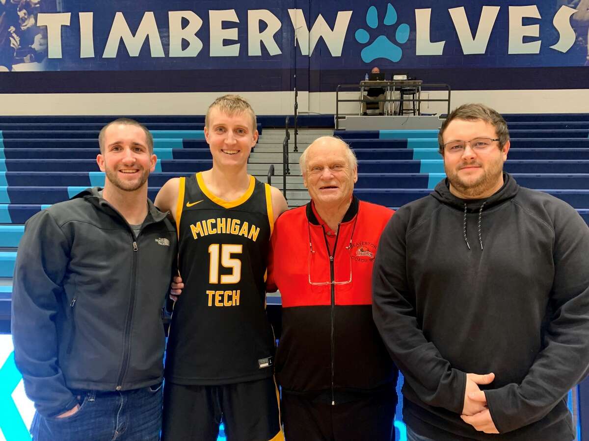 Michigan Tech junior guard Carter Johnston (second from left) poses with his brothers Spencer Johnston (far left) and Grant Johnston (far right) and their grandfather Roy Johnston following Saturday's win over Northwood, Dec. 4, 2021.