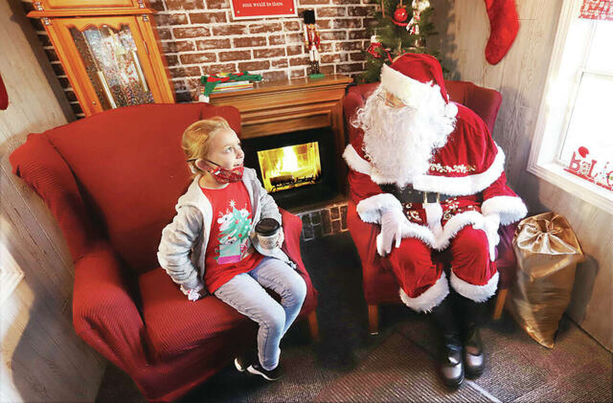 Malaia Broyles, 7, of East Alton ponders what she wants for Christmas as she visits with Santa Claus Saturday at Santa’s Cottage on wheels outside the East Alton Municipal Building. Santa’s Cottage was a centerpiece of East Alton's “A Night of Christmas” held 4-8 p.m. on Saturday.