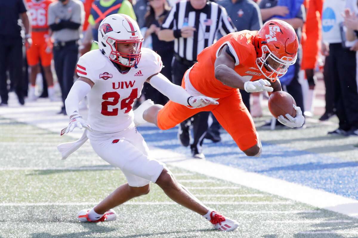 Sam Houston running back Noah Smith, right, dives for extra yards past Incarnate Word defensive back Elliott Davison (24) during the first half of a football game Saturday, Dec. 4, 2021 in Huntsville, TX.