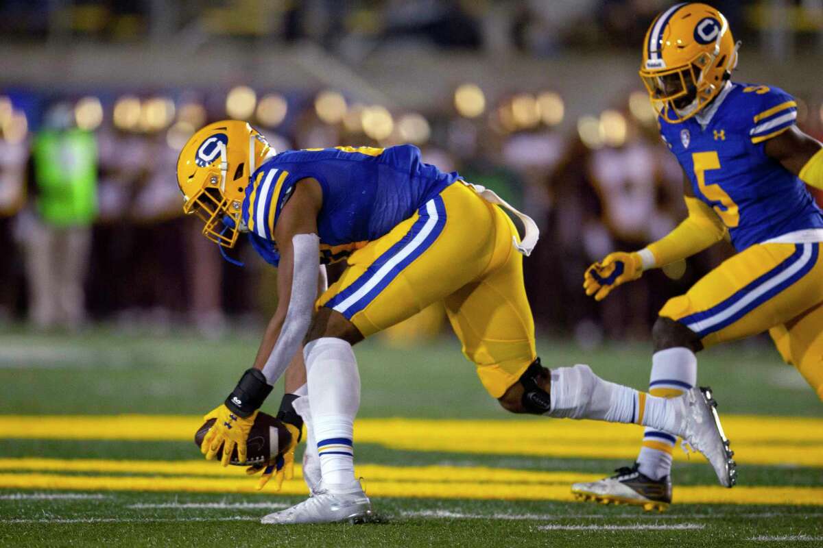 California inside linebacker Trey Paster (27) scoops up a fumble by Southern California tailback Darwin Barlow before returning it 55 yards for a touchdown during the second quarter of an NCAA college football game, Saturday, Dec. 4, 2021, in Berkeley, Calif. (AP Photo/D. Ross Cameron)