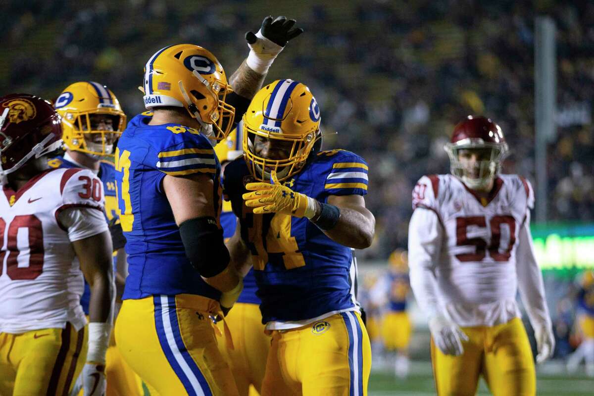 California running back Christopher Brooks (34) is congratulated by Brayden Rohme (63) after scoring a touchdown against Southern California during the second quarter of an NCAA college football game, Saturday, Dec. 4, 2021, in Berkeley, Calif. (AP Photo/D. Ross Cameron)