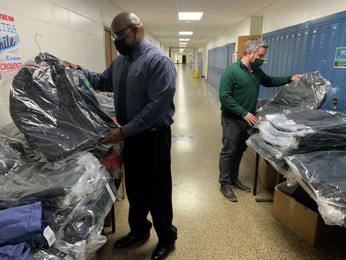 Ponus Ridge School Principal Damon Lewis and assistant principal Evan Byron check the coats donated by Dalio Education for the school's annual coat drive on Thursday, Dec. 3, 2021.