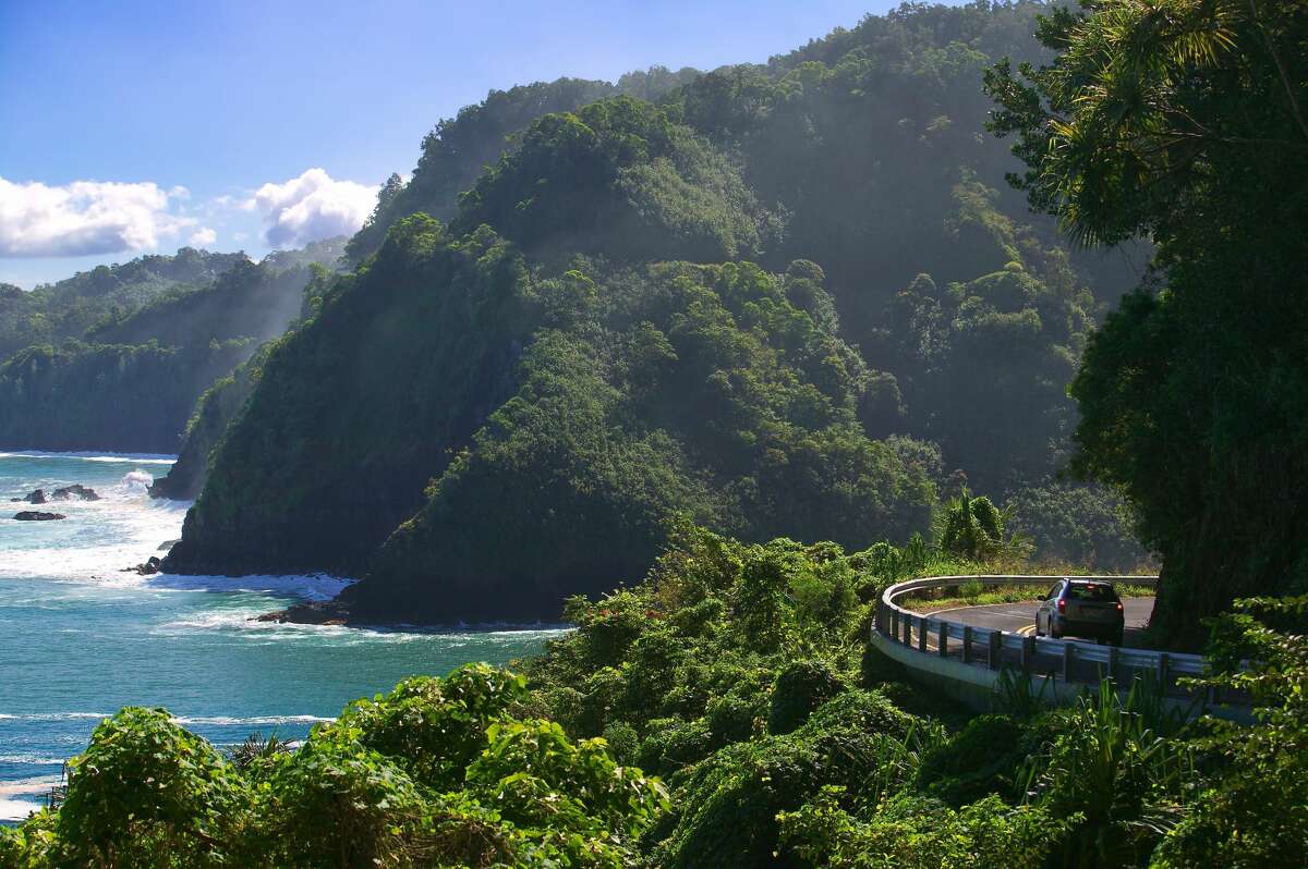 Curvy coastal road with views of cliffs, beaches, waterfalls.