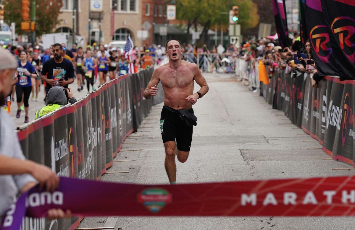 Men’s marathon winner Colin Marz grimaces as he finishes the Rock ’n’ Roll Marathon on Sunday morning. The number of runners was estimated at 14,000.