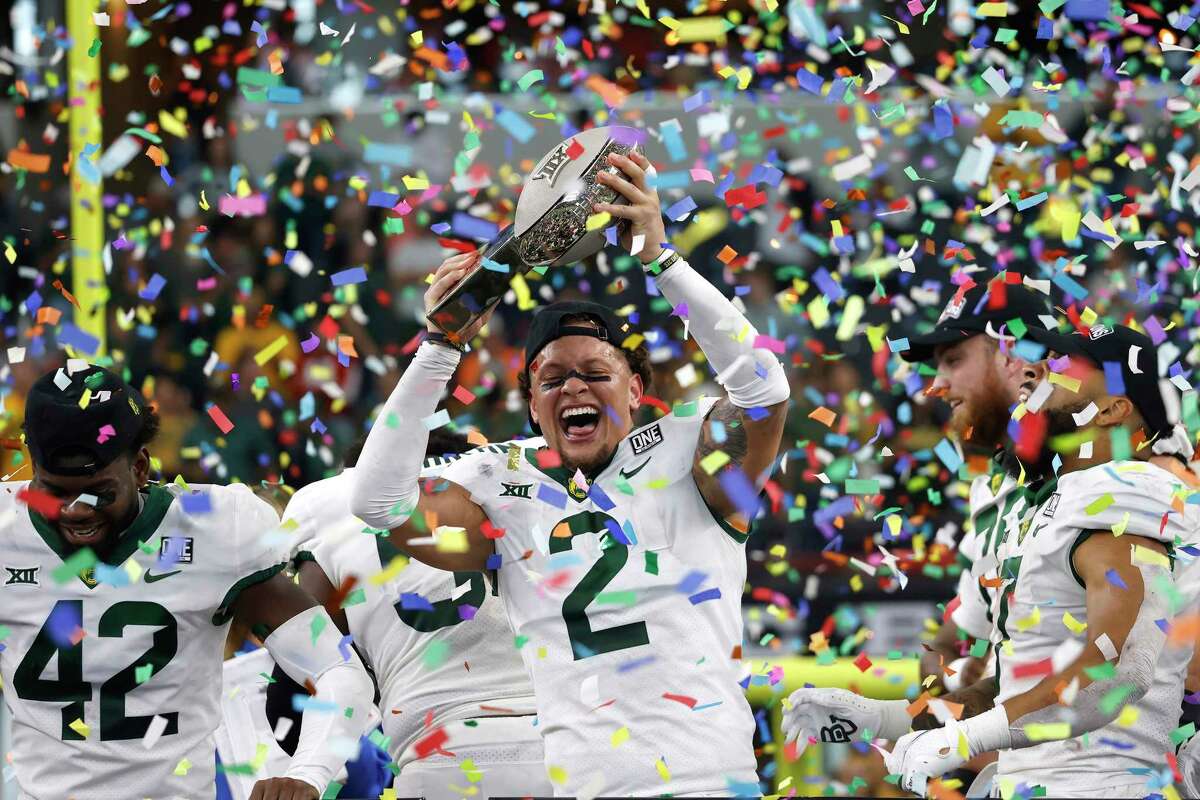 Baylor's Terrel Bernard (2) hoists the Big 12 Championship trophy and celebrates with teammates after the Bears defeated Oklahoma State, 21-16, in the Big 12 Football Championship at AT&T Stadium on Saturday, Dec. 4, 2021, in Arlington, Texas.
