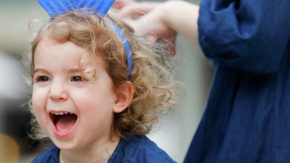 Sara Blecher yells with joy as music plays after a nine-foot menorah is lit during the annual celebration of Hanukkah at Market Street, Sunday, Dec. 5, 2021, in The Woodlands. For the last decade, Chabad of The Woodlands has held the event in celebrate the Jewish holiday tradition as a community-wide celebration.