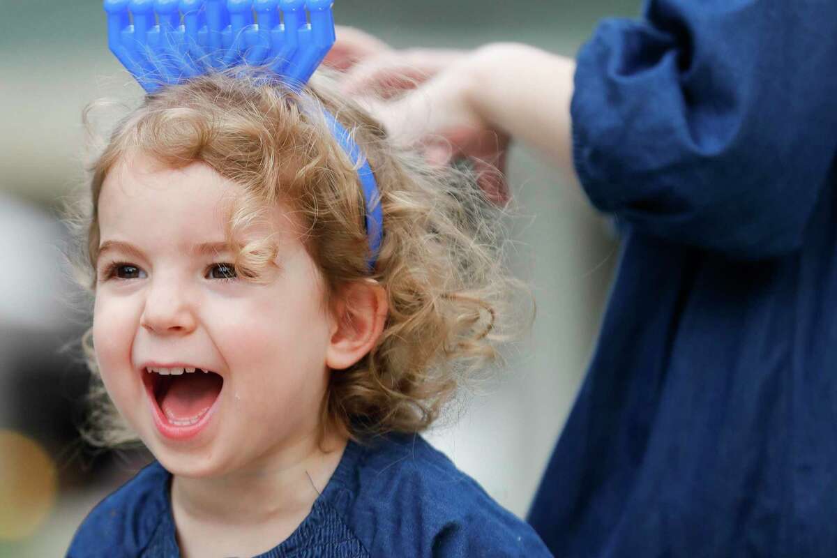 Sara Blecher yells with joy as music plays after a nine-foot menorah is lit during the annual celebration of Hanukkah at Market Street, Sunday, Dec. 5, 2021, in The Woodlands. For the last decade, Chabad of The Woodlands has held the event in celebrate the Jewish holiday tradition as a community-wide celebration.