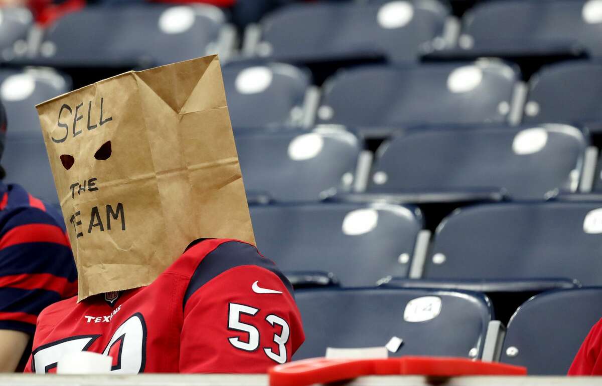A Houston Texans fan with a bag on his head that reads 'Sell the team' with empty seats behind him during the second half of an NFL football game at NRG Stadium, Sunday, Dec. 5, 2021 in Houston.