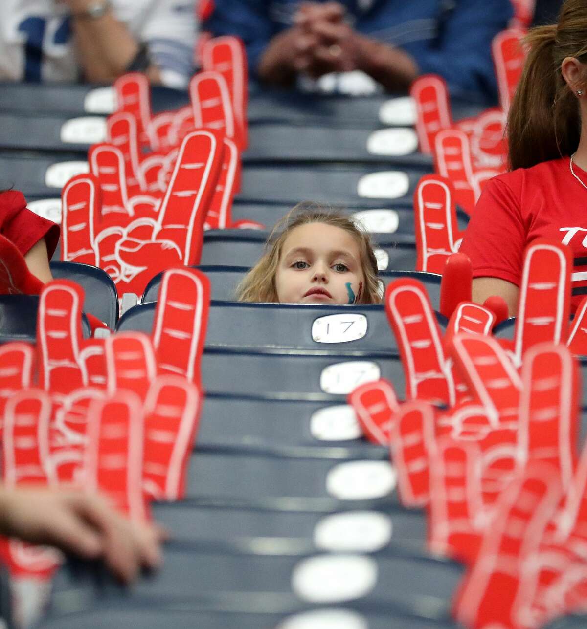 A little Houston Texans fan in her seats surrounded by foam hands during warmups before an NFL football game at NRG Stadium, Sunday, Dec. 5, 2021 in Houston.