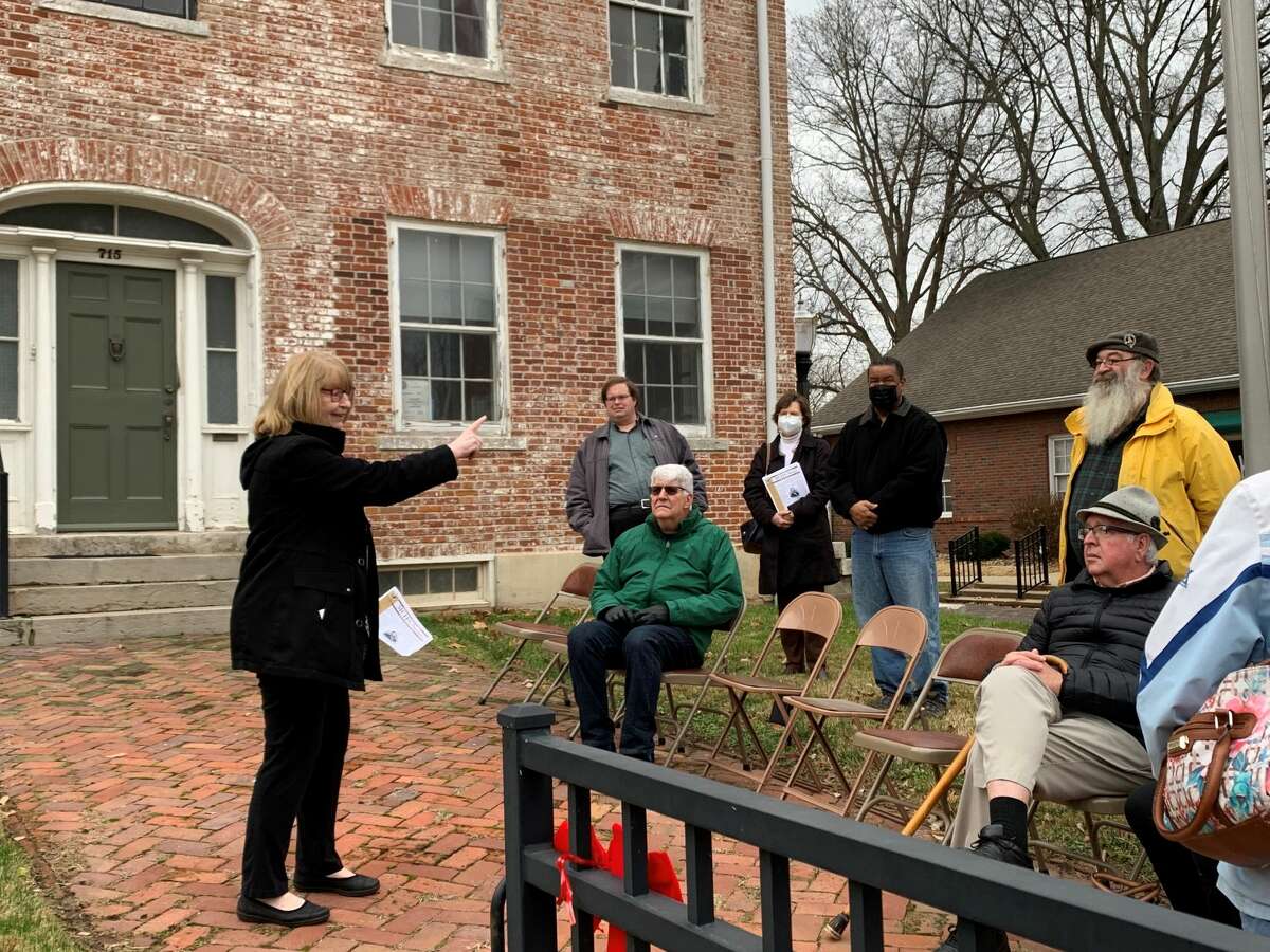 Cindy Reinhardt (left) talking about the history of Dr. John Weir to members of the local public who came to see the new historical marker for Weir on Sunday. Reinhardt is on the board of directors for the Madison County Historical Society. 