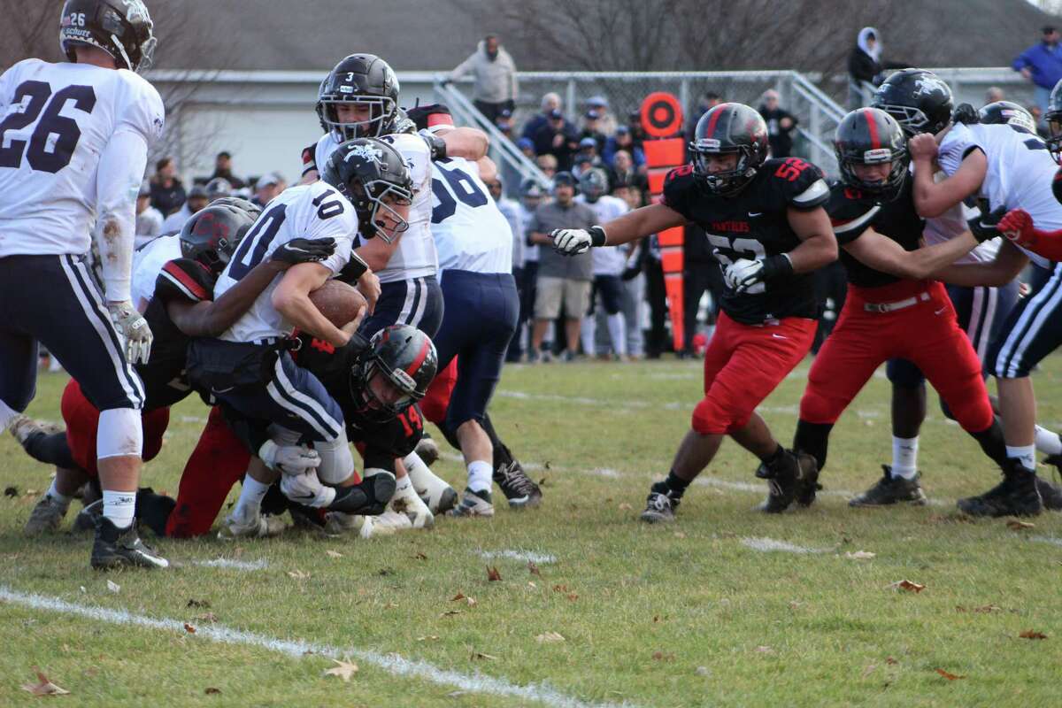 Ansonia quarterback Christopher Kaminski is sacked in the first half by two Panthers defenders, including Alex Hair (14).