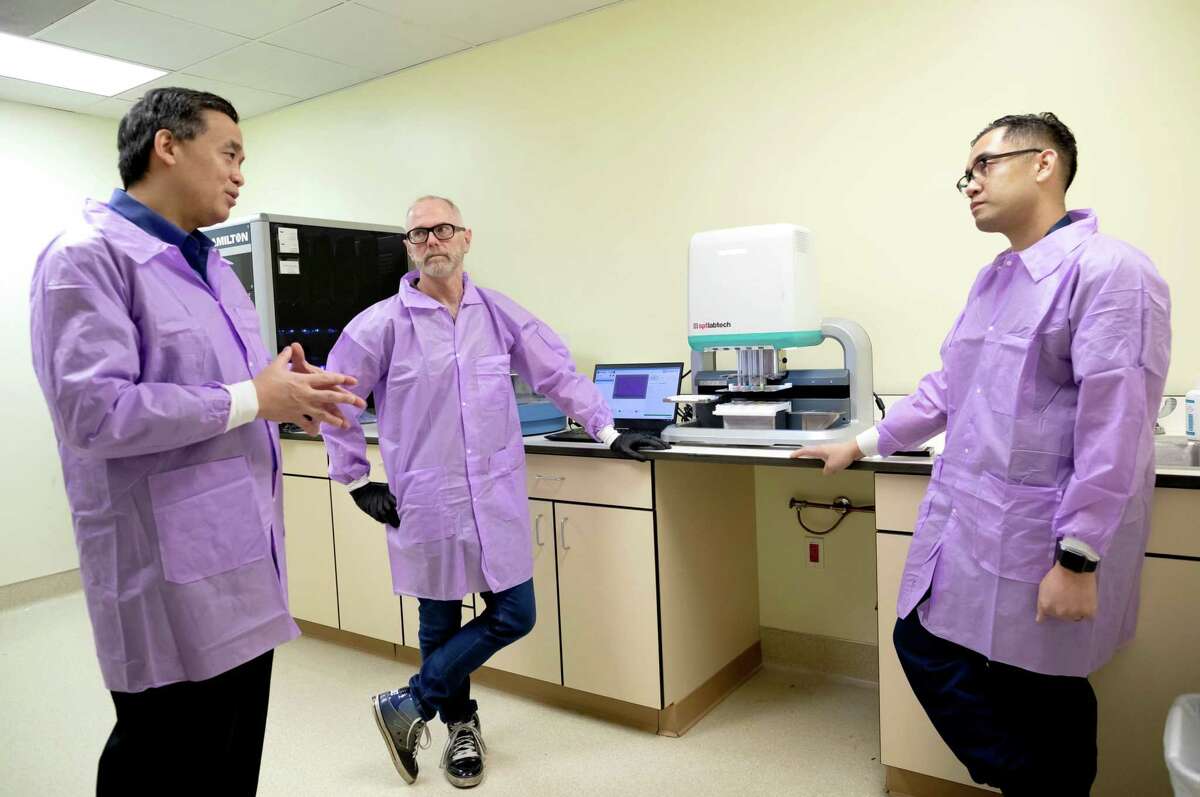 Charles Chiu, MD, PhD, left, professor of Laboratory Medicine and Medicine in the Division of Infectious Diseases, and director of the UCSF-Abbott Viral Diagnostics and Discovery Center, talks with Chris Waddling, PhD, center, application scientist at SPT Labtech, and Shaun Arevalo, far right, clinical laboratory scientist and Metagenomic NGS Specialist for Clinical Microbiology, at their China Basin lab where they’ll process COVID-19 samples and sequence their genomes.