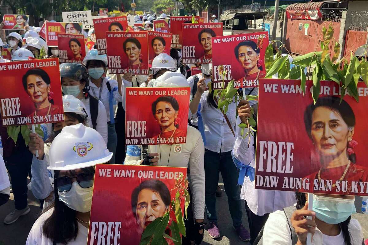 FILE - Protesters hold portraits of deposed Myanmar leader Aung San Suu Kyi during an anti-coup demonstration in Mandalay, Myanmar on March 5, 2021. Myanmar court on Monday, Dec. 6, 2021 sentenced ousted leader Suu Kyi to 4 years for incitement, breaking virus restrictions.