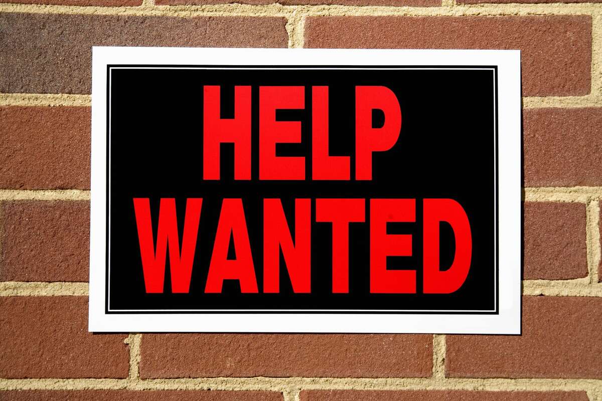 A file image of a help wanted sign on a brick building. 