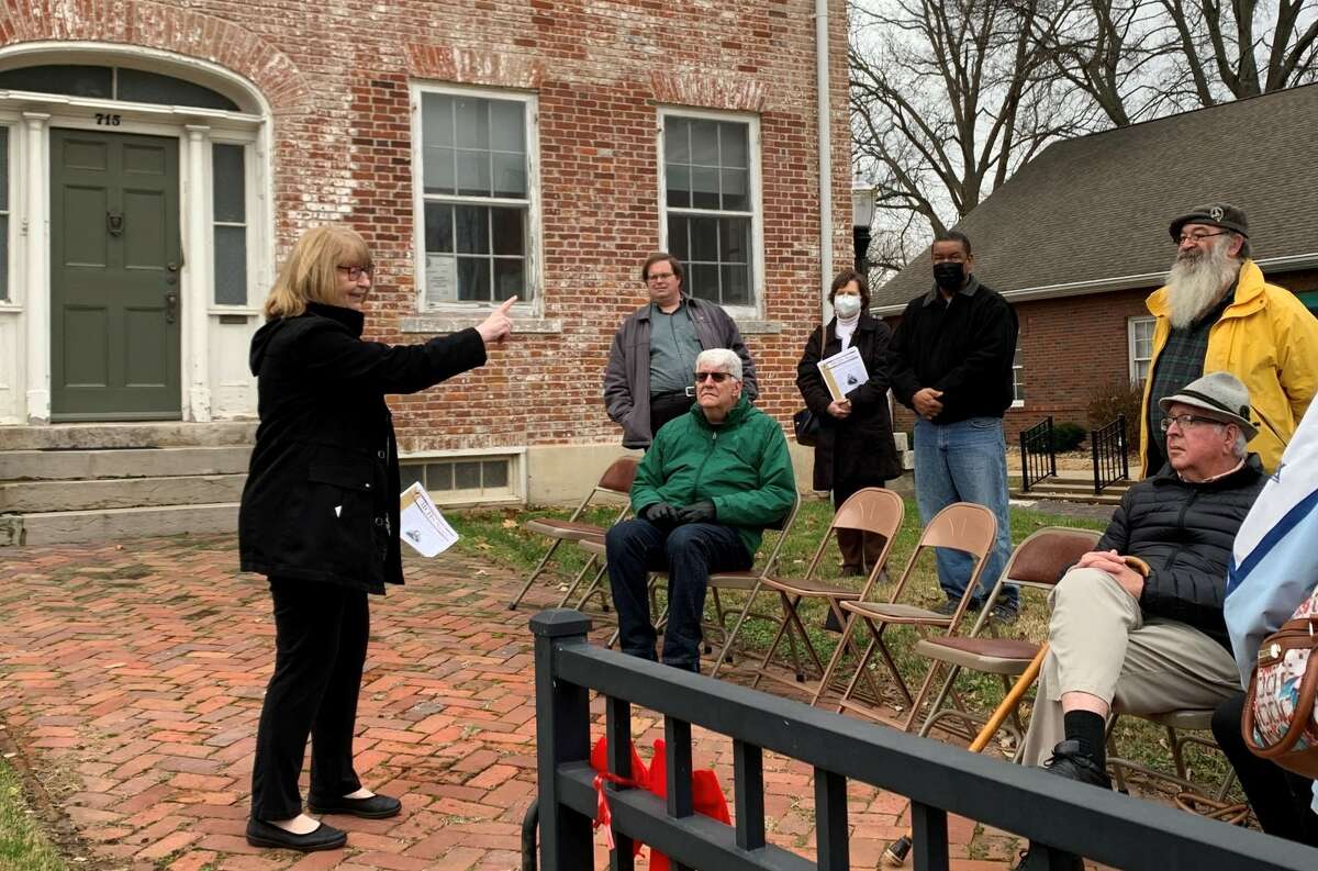 Cindy Reinhardt, left, talks about the history of Dr. John Weir to people who came to see the new historical marker for Weir on Sunday. Reinhardt is on the board of directors for the Madison County Historical Society. 