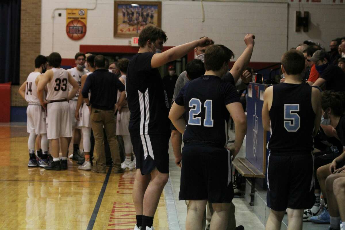 Brethren basketball huddles up during a timeout against Manistee Catholic Central. 