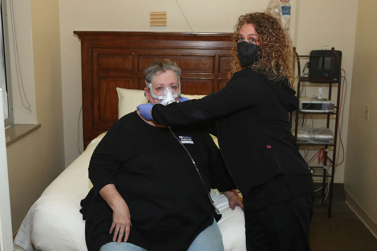 Rachael Beane, a sleep tech in the Alton Memorial Hospital Sleep Diagnostics Center, right, adjusts the CPAP mask on Pamela Voyles.