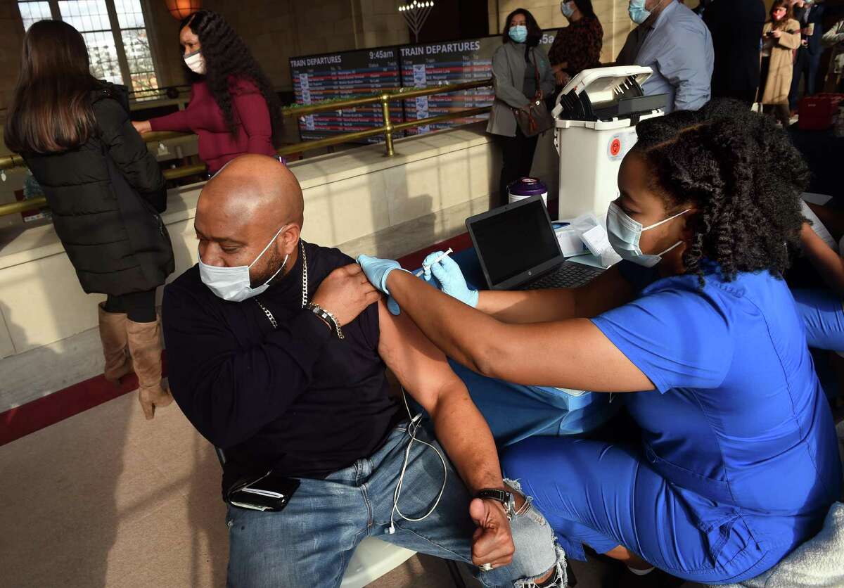 A person gets COVID-19 vaccine at Union Station in New Haven Dec. 6, 2021.