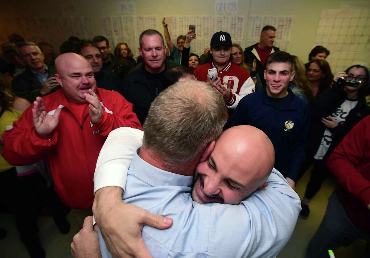 Rich Dziekan (center left) hugs campaign manager Andrew Baklik at his headquarters in Derby after results showed Dziekan as the winner in the Derby mayoral race on November 7, 2017.