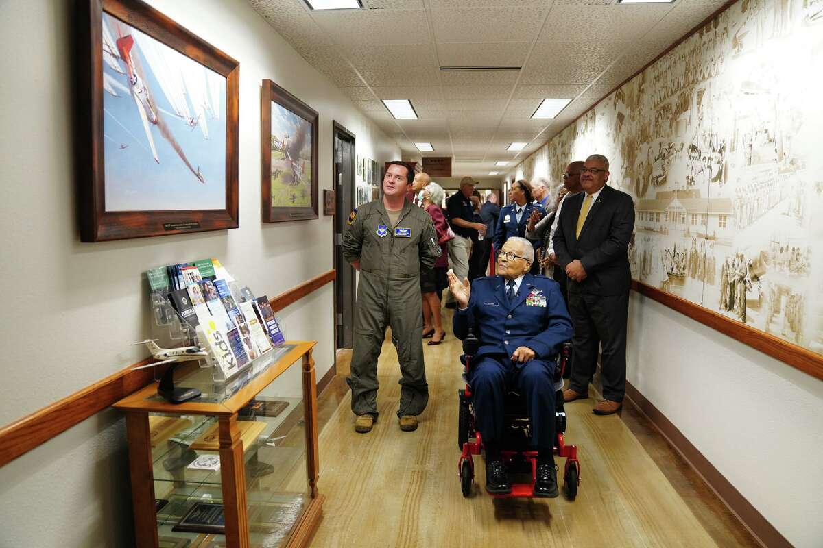 Retired Brig. Gen. Charles McGee and Major Nick Fairbrother look over historical prints Monday at the Air Force 99th Flying Training Squadron at Joint Base San Antonio-Randolph. McGee, a Tuskegee Airman, turns 102 on Tuesday.