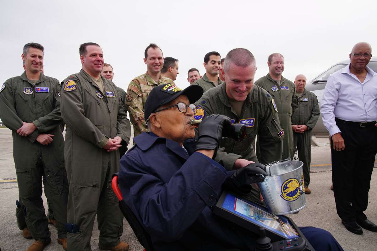 Retired Brig. Gen. Charles McGee drinks a Coca-Cola during events Monday at the 99th Flying Training Squadron at Joint Base San Antonio-Randolph. McGee, a Tuskegee Airman, turns 102 on Tuesday. Looking on is Lt. Colonel Cory Henwood.