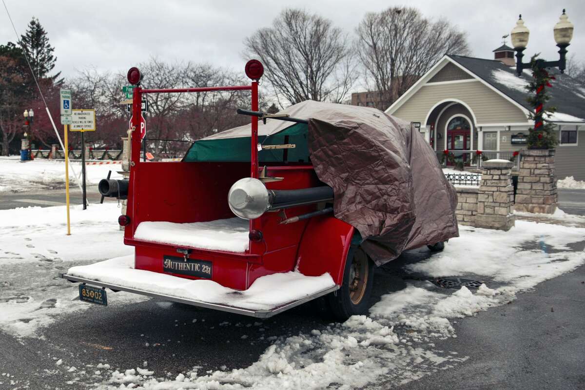 A tarp protects an antique car purchased by Authentic 231, that a man dressed as Santa usad as his sleigh during Old Chirstmas and the Manistee Victorian Sleighball parade. Four inches of snow fell between Sunday and Monday in Manistee, according to the National Weather Service. In addition, a winter weather advisory was issued until 10 p.m. Monday Night.