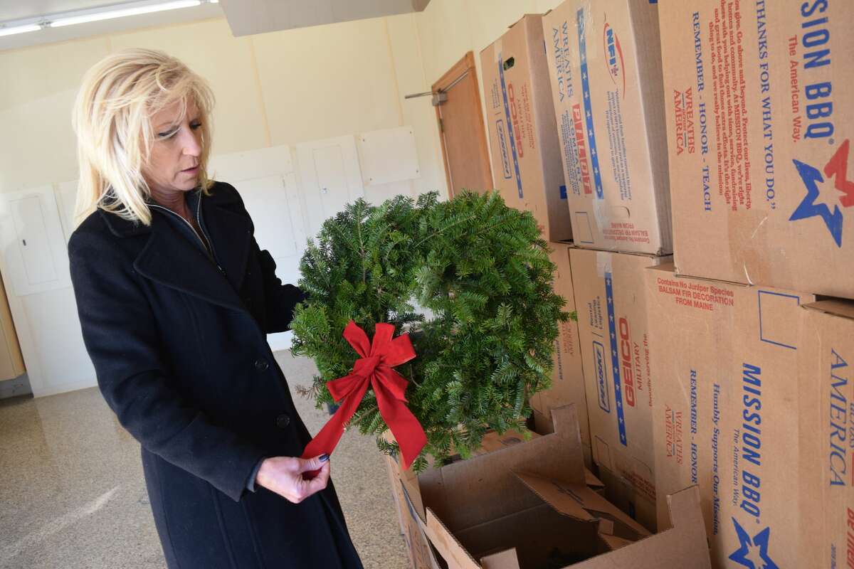 Sarah Shellhammer, owner of WJIL/WJVO radio stations, examines a wreath for the Wreaths Across America program Monday at Williamson Funeral Home. The wreaths will be placed on the graves of veterans Dec. 18. 
