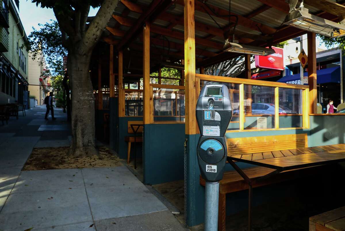 A parking meter stands beside the Snug's parklet in San Francisco. Restaurants are facing more than 60 pages of guidelines for the Shared Spaces program.