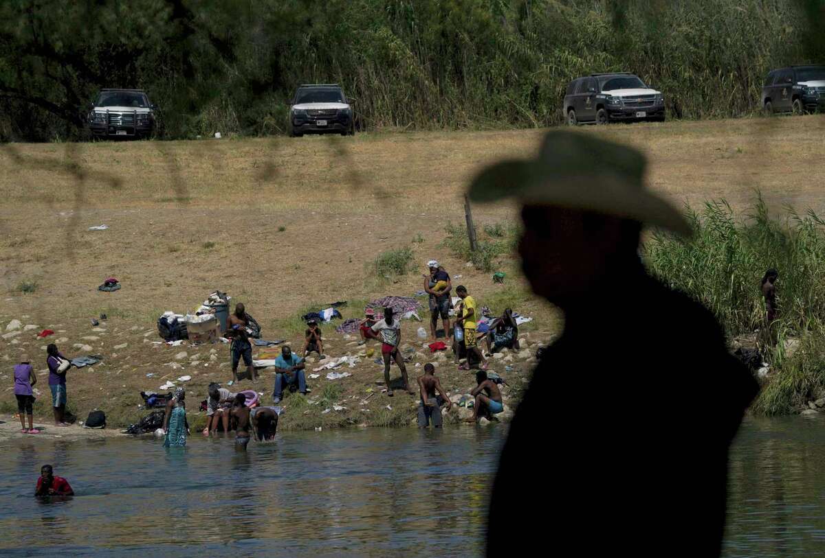 FILE - Migrants, many from Haiti, wade across the Rio Grande from Del Rio, Texas, to return to Ciudad Acuna, some to avoid possible deportation from the United States and others to get supplies, on Sept. 22, 2021. A year into the Joe Biden’s presidency, though, action on the immigration system has been hard to find and there is growing consternation privately among some in the party that the Biden administration can’t find the right balance on immigration. (AP Photo/Fernando Llano, File)