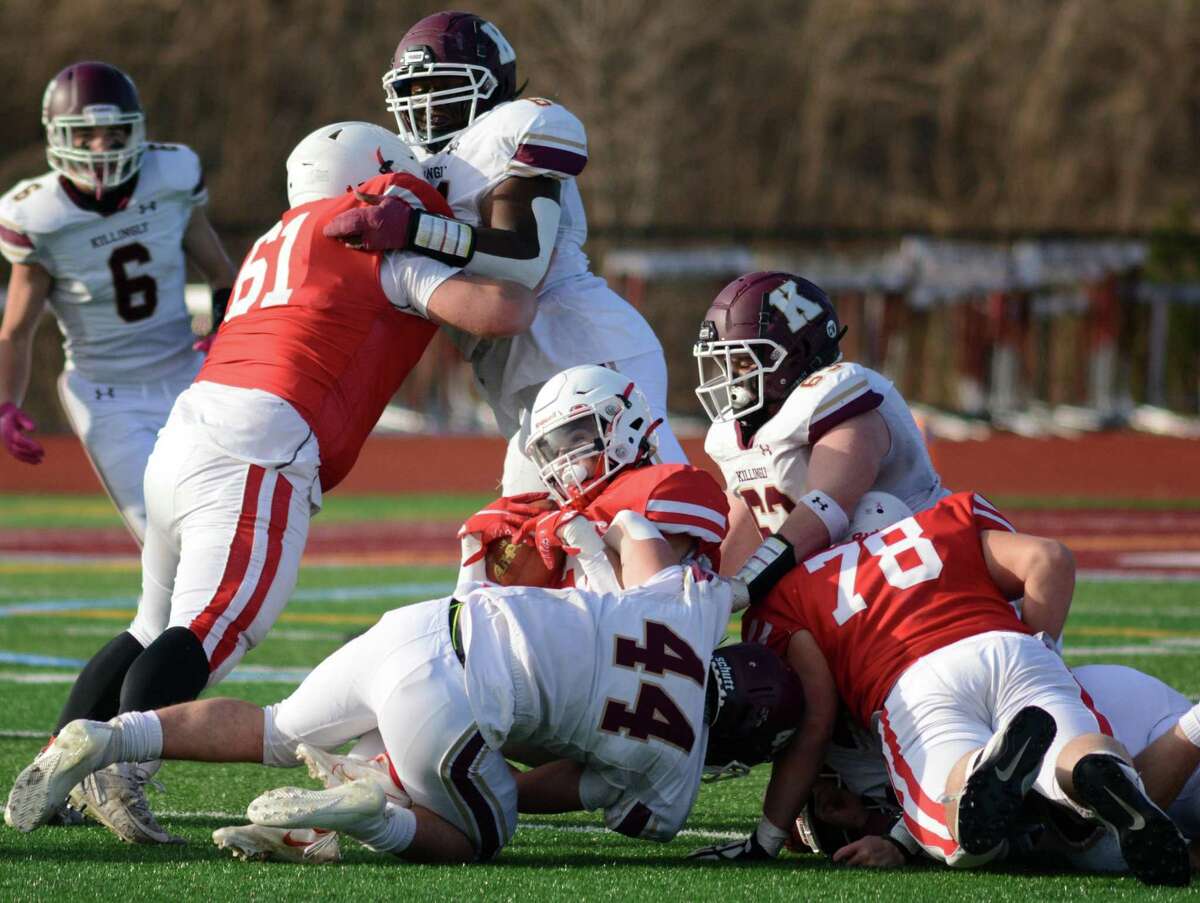 Branford's Nate Chieffo lands on top of the pile after gaining yardage during the Class M semifinals.