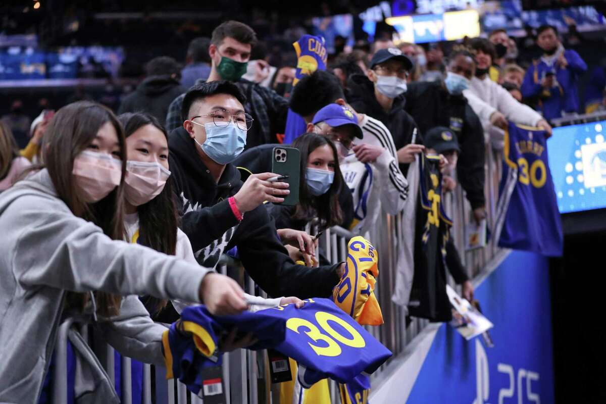 Golden State Warriors' fans try to get Stephen Curry's attention before Warriors' NBA game against Philadelphia 76ers at Chase Center in San Francisco, Calif., on Wednesday, November 24, 2021.