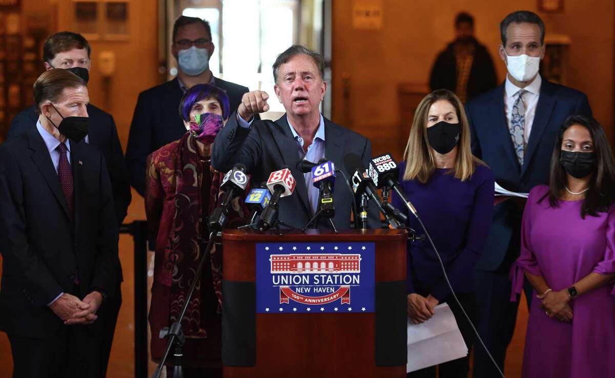 Governor Ned Lamont (center) speaks at a press conference urging Connecticut residents to get a COVID-19 booster shot at Union Station in New Haven on December 6, 2021. The Connecticut Department of Public Health has set up a pop-up vaccine clinic at Union Station to administer vaccinations and booster shots.