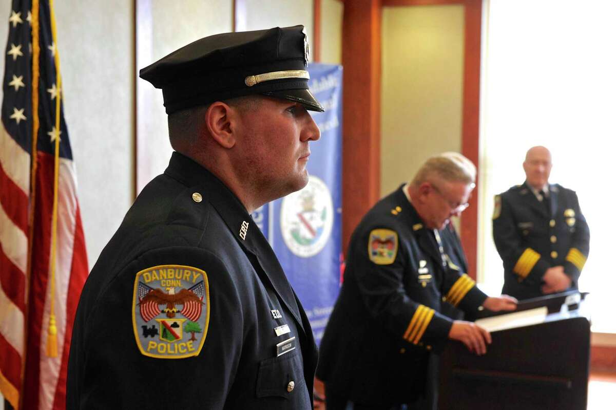 Officer Andrew Katkocin listens as Deputy Chief Shaun McColgan reads the reasons for him being awarded a Meritorious Citation during the Danbury Police Department’s 2016 Memorial Service & Annual Awards Ceremony.