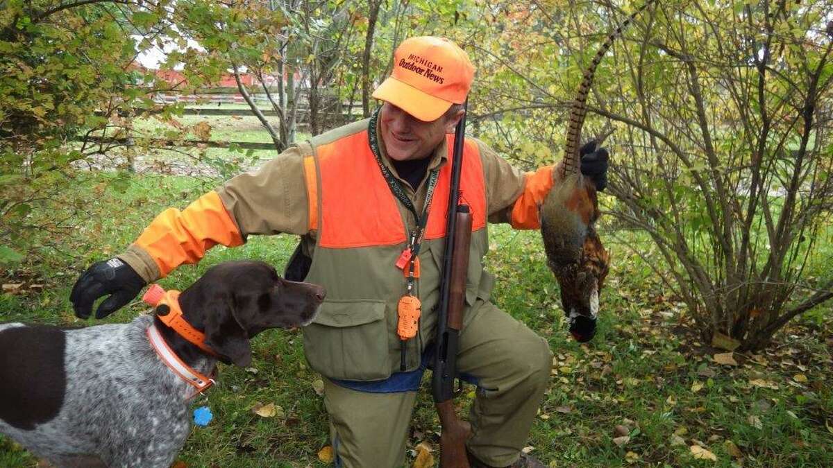Outdoor writer Bill Parker and his German shorthaired pointer, Brady, share a successful moment during a pheasant hunt in the Thumb.