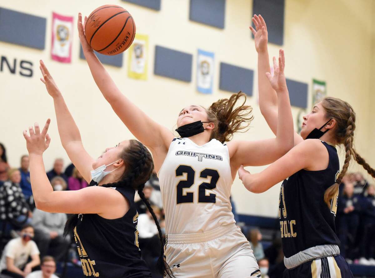 Father McGivney's Charlize Luehmann, middle, goes up for a rebound against Althoff during the first half of Monday's game in Glen Carbon.