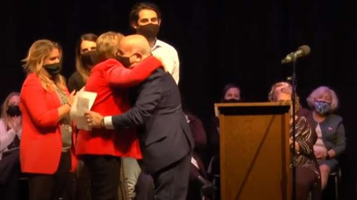 First selectman Vicki Tesoro hugs husband Tom Tesoro after he swears her in for a third term in the office during a ceremony Dec. 6, 2021 at Trumbull High School.