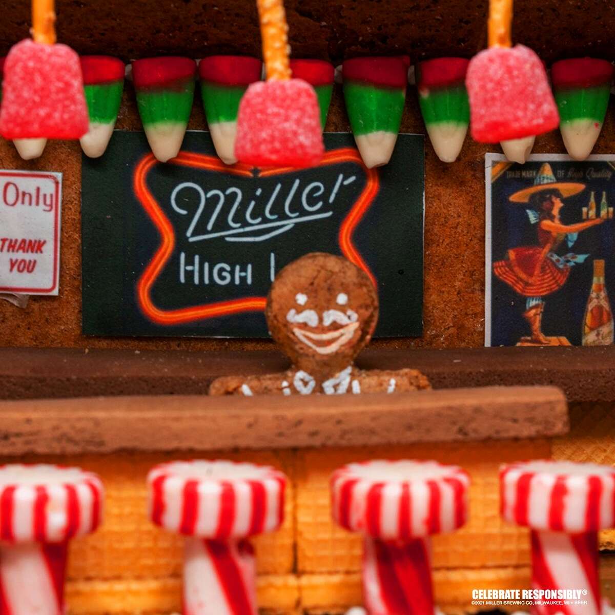 A shot of the inside shows a gingerbread bartender behind a bar partially crafted from wafer cookies along a row of peppermint barstools.