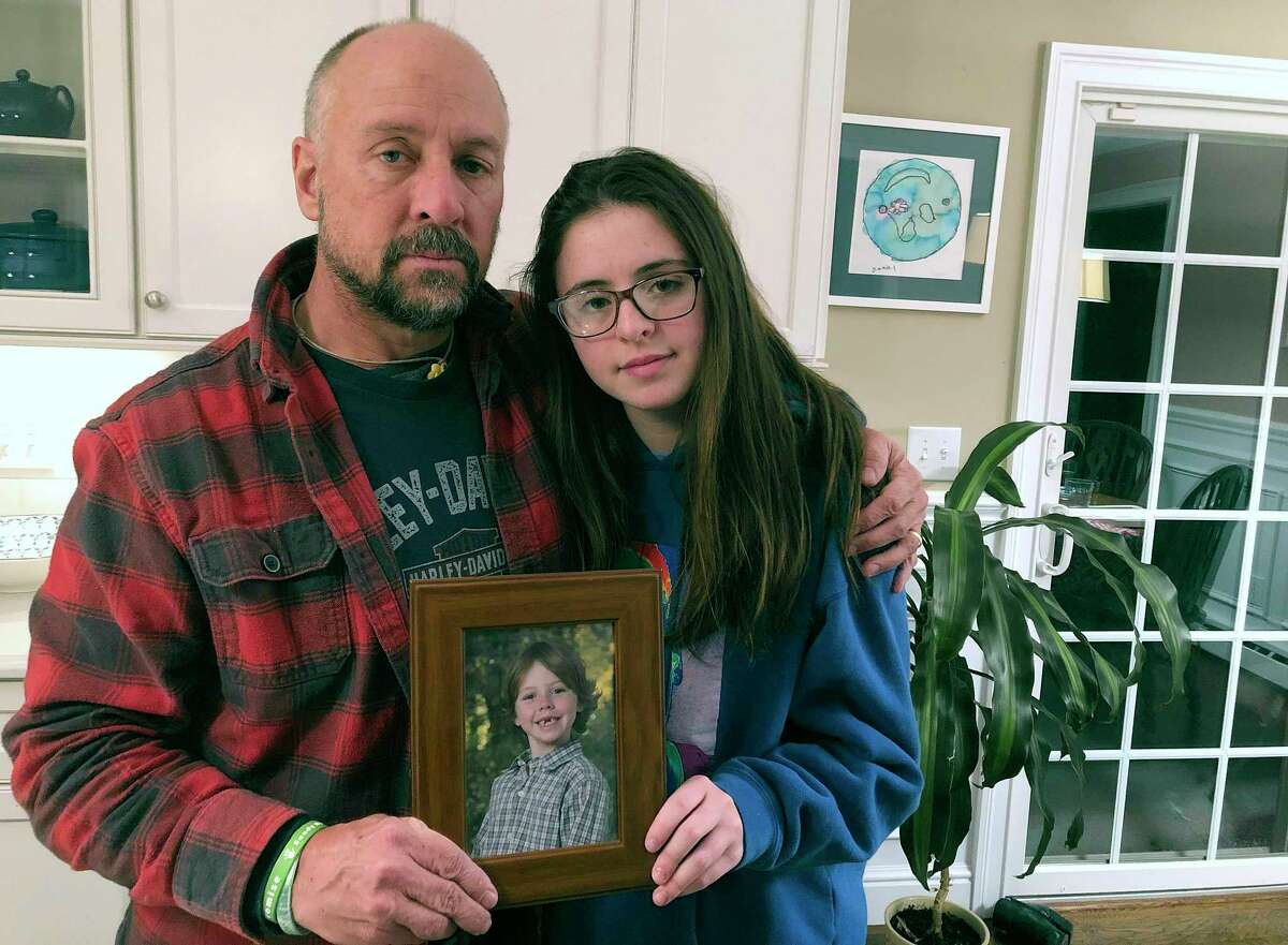Mark Barden and his daughter Natalie Barden hold a photograph of Daniel at their home in Newtown, Conn. Daniel died in the Dec. 14, 2012, Sandy Hook Elementary School shooting that killed 20 first graders and six educators. Mark Barden is co-founder and CEO of the homegrown nonprofit, Sandy Hook Promise.