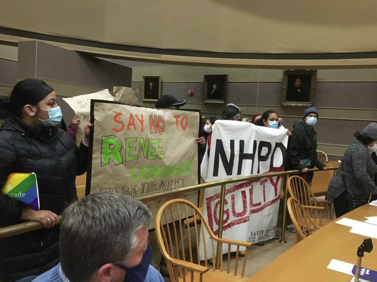 About 30 protesters stood on one side of the New Haven Board of Alders chamber, urging the board to deny Mayor Justin Elicker’s appointment of Interim Chief Renee Dominguez to be police chief.
