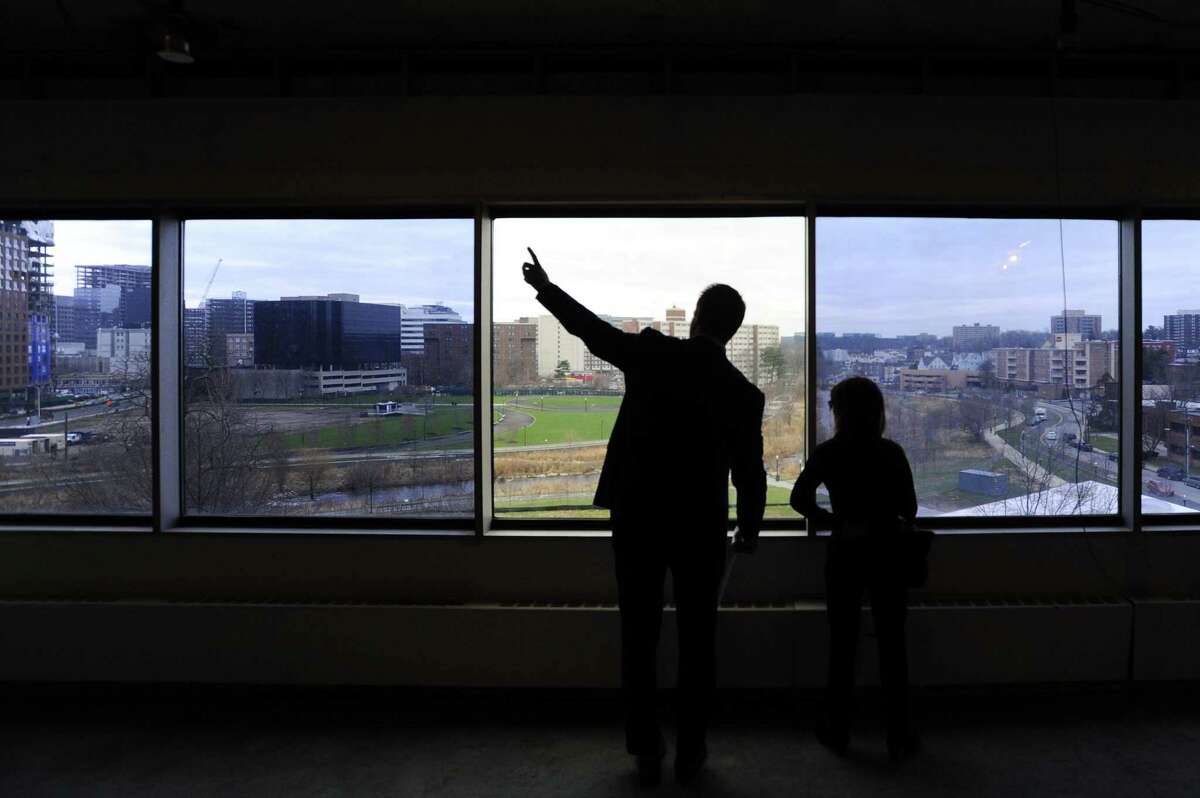 Rhys Executive VP Christian Bangert points to the view of Mill River Park and downtown Stamford while giving a tour of a vacant office space inside 9 West Broad St. in Stamford, Conn. on Thursday, April 6, 2017.
