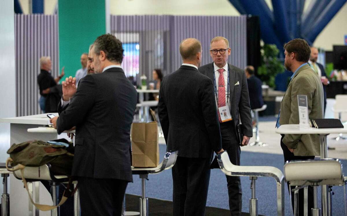 Attendees gather and talk at the exhibition hall during the second day of the World Petroleum Congress Tuesday, Dec. 7, 2021, at George R. Brown Convention Center in Houston.